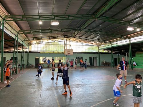 The men's baskeball team shoots hoops at an at-risk youth clinic