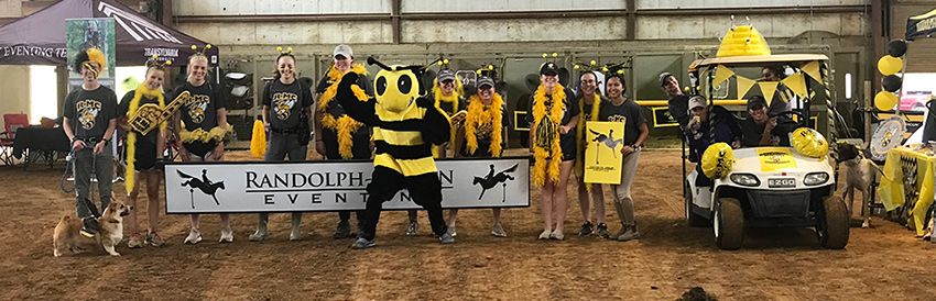 Equestrian team with yellow jacket mascot holding a banner