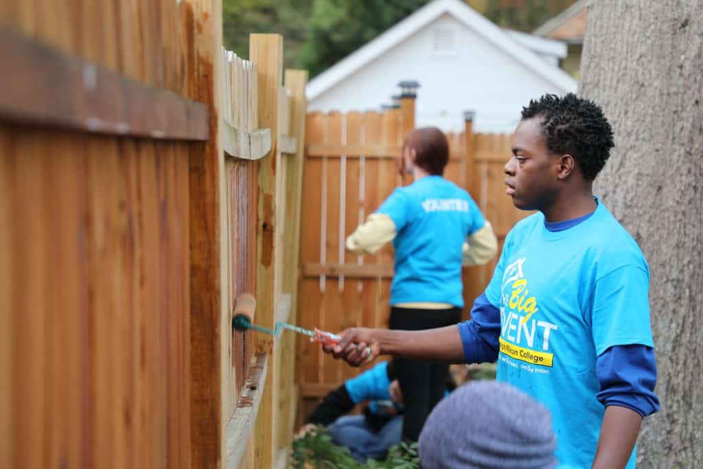 student painting a gate