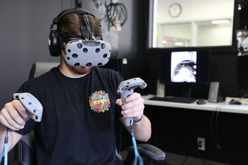 A student participates in a virtual reality experience in the Makerspace area of the Library