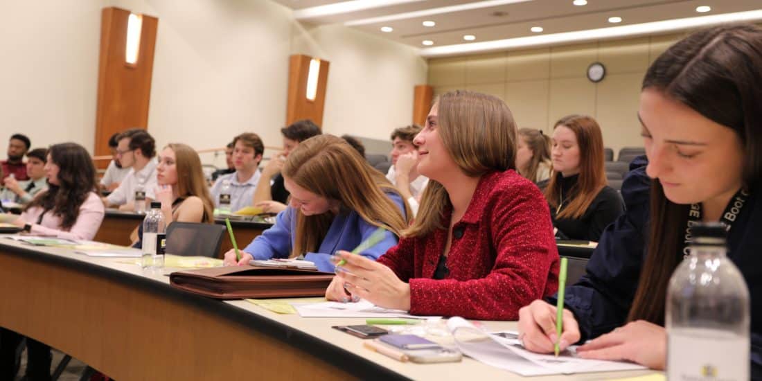 A group of RMC students listen and take notes during the Edge Boot Camp