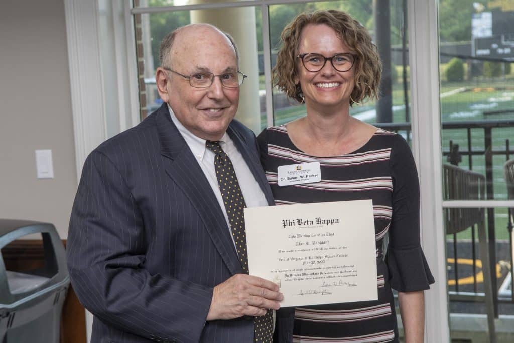 Alan Rashkind holding a certificate of recognition with Dr. Susan Parker