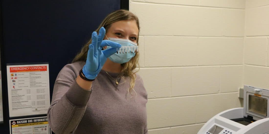 Elise Knobloch holding a container of samples