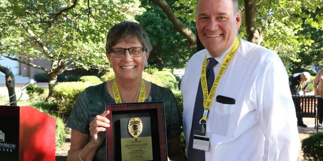 Recently retired Associate Dean of Students Kathryn Hull poses alongside Den of Students Grant Azdell holding a plaque commemorating her years of service.