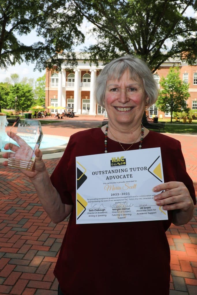 Maria Scott poses with her Outstanding Tutor Advocate award