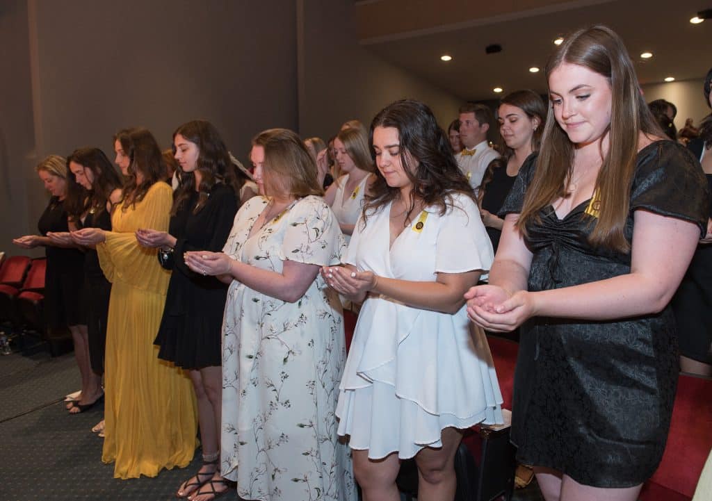 The inaugural class of RMC nursing graduates receives a Blessing of the Hands during the pinning ceremony