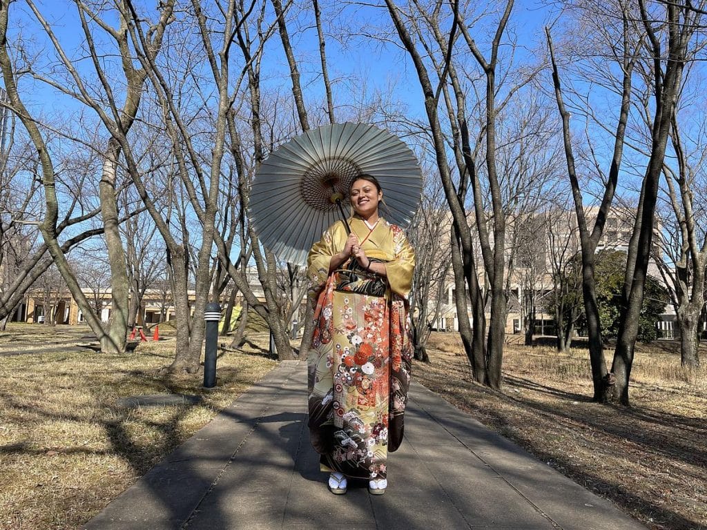 A woman wearing a kimono and holding a parasol