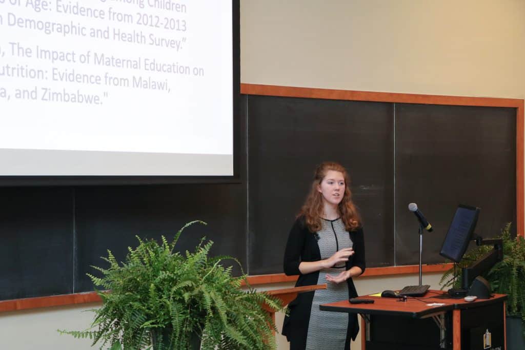 Student standing at podium giving a presentation