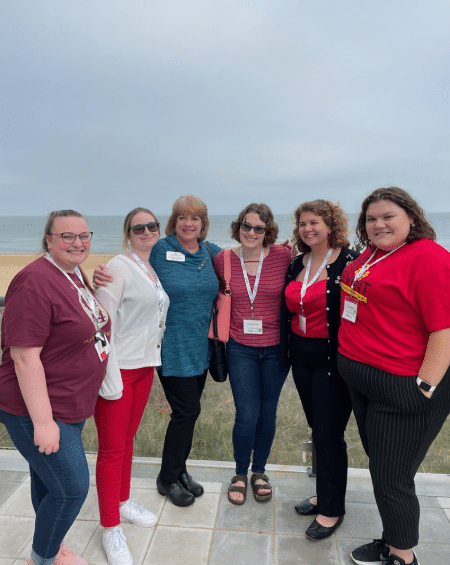Students and their Faculty Advisor stand together smiling at the camera