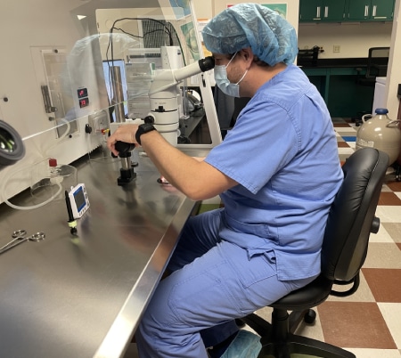 Tyl Taylor looking int0 a microscope in a lab