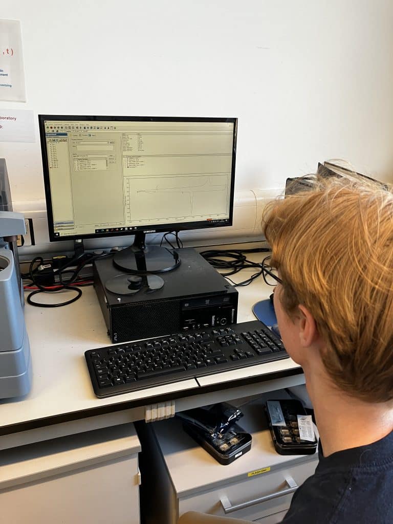 Will Adair ‘24 uses a differential scanning calorimeter to conduct freezing point experiments at the University of Cambridge’s chemistry department.