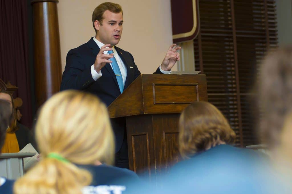 student at a podium speaking during a debate competition