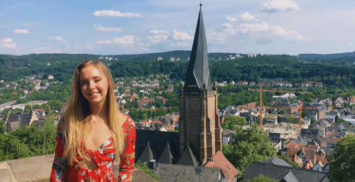 RMC German student smiles in front of historic building while studying abroad