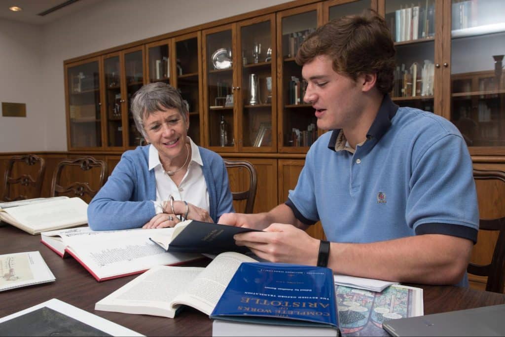 Faculty member working with English student sitting at a table