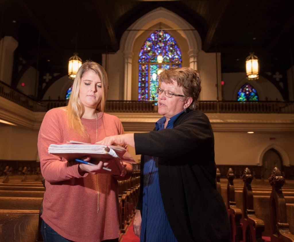 Two and clergy member review biblical text
