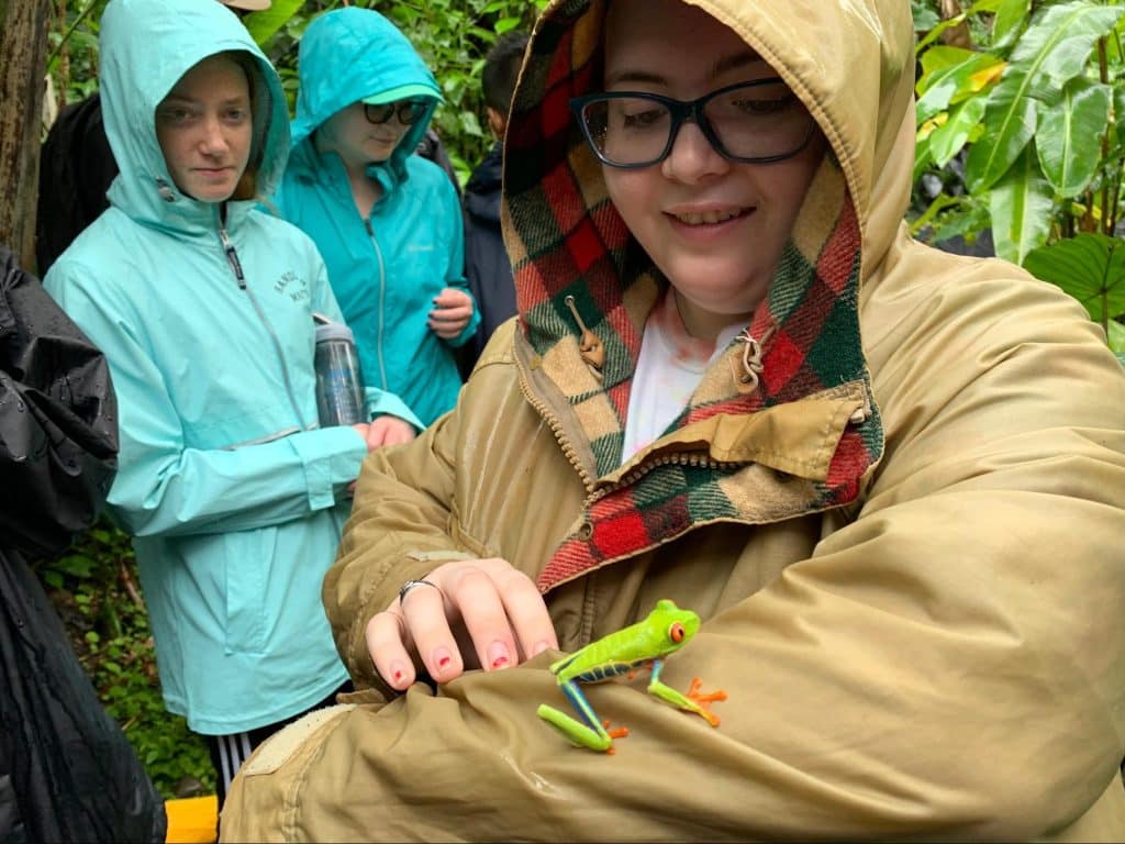 Student with tree frog rested on her arm