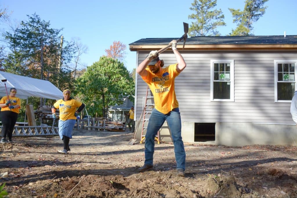 Sociology and Anthropology Student using hoe to dig ground while volunteering for Habitat for Humanity