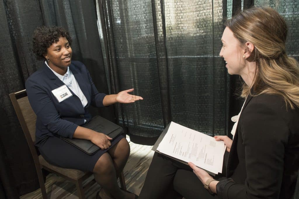 A RMC student and volunteer sit facing each other conducting a mock interview during the Edge Boot Camp.