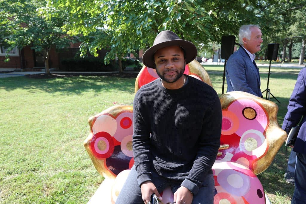 Sculpture artist Alex Goastièr sits on the cherry blossom sculpture