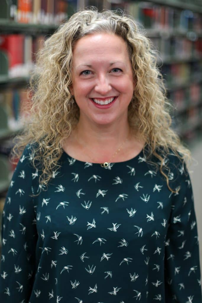 A woman with curly hair receives prestigious awards from RMC Honors.