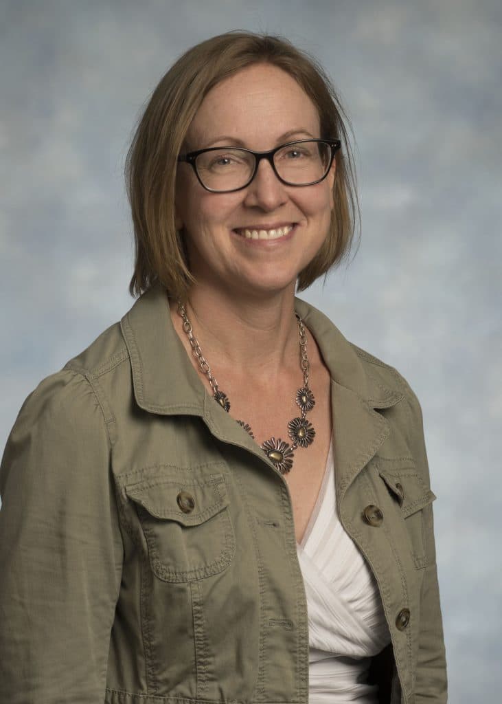 RMC Honors Faculty Members with Prestigious Awards, including a woman wearing glasses and a green jacket.