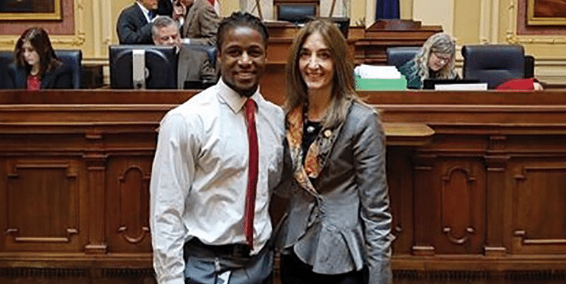 A Scholar and Athlete posing for a picture in a courtroom.