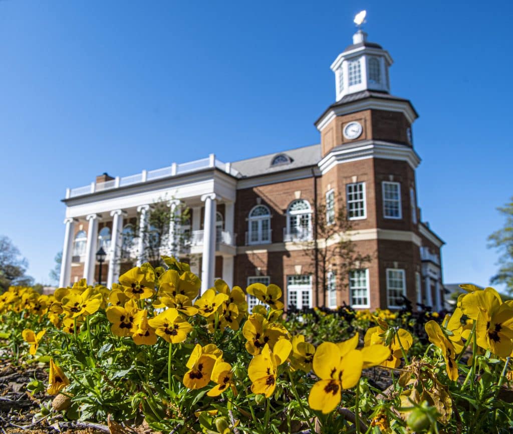 A photo of Brock Commons with yellow flowers in the foreground. 