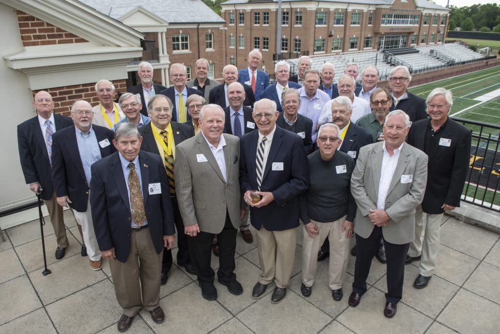 A group of Boydton Society members posing for a picture on a rooftop.