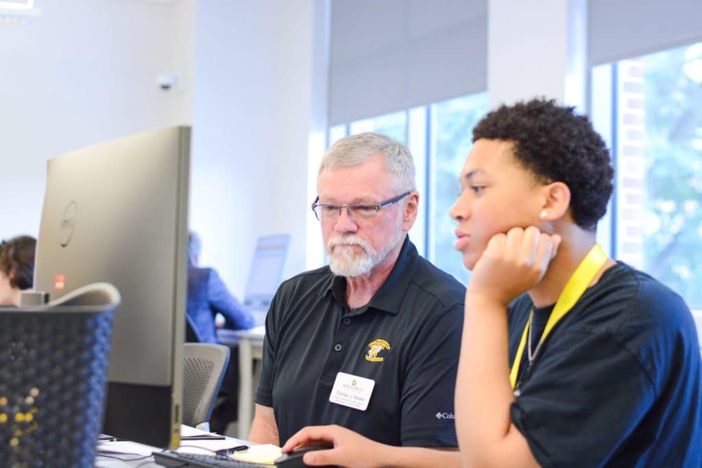 A man and a woman transitioning to college sitting at a desk in front of a computer.