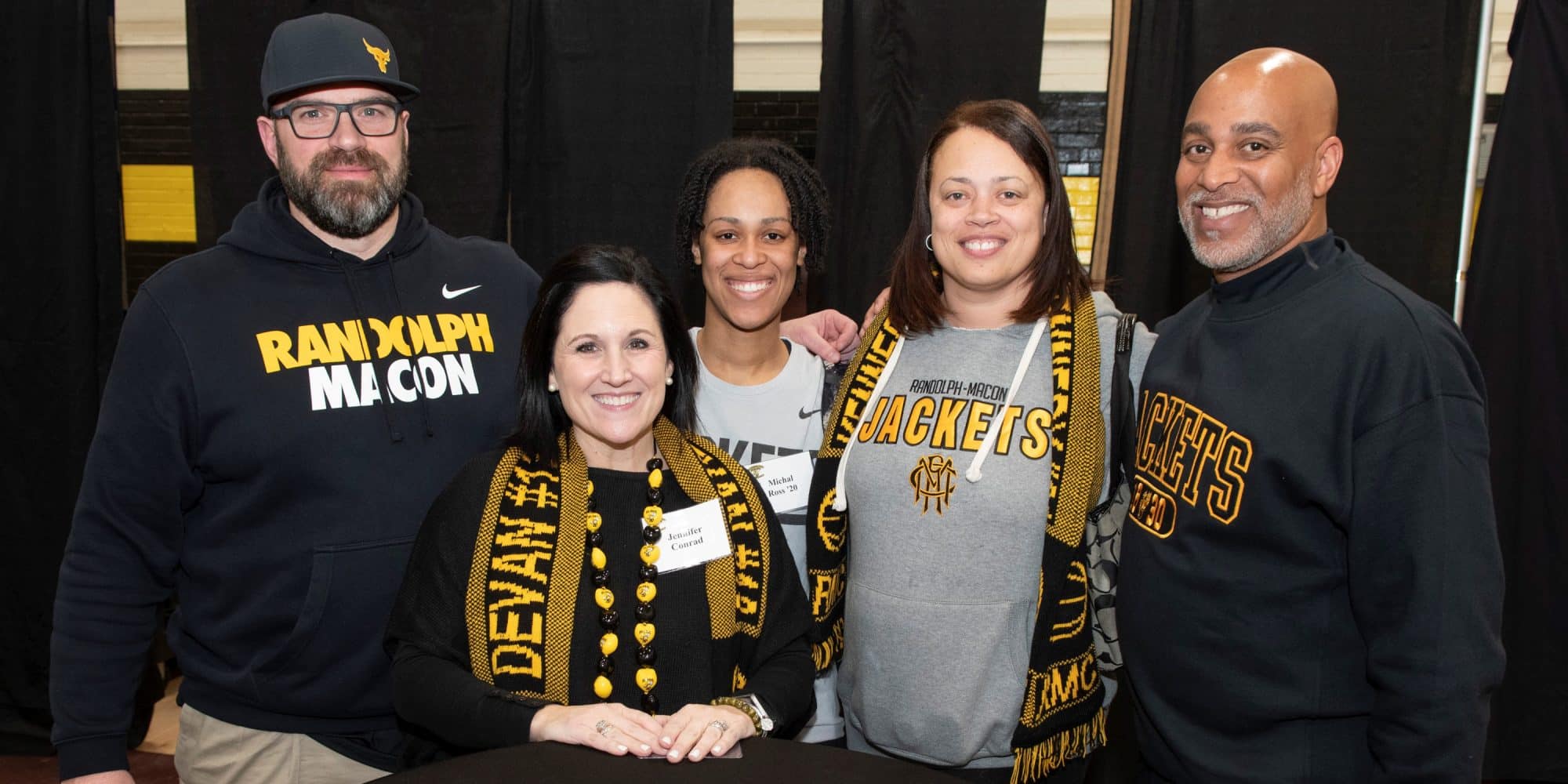 A group of RMC alumni pose for a photo in RMC apparel