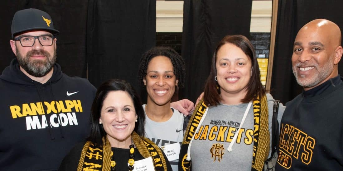 A group of RMC alumni pose for a photo in RMC apparel