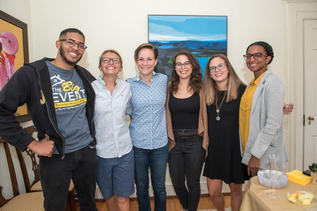 A group of young alumni pose for a photo during a homecoming activity 