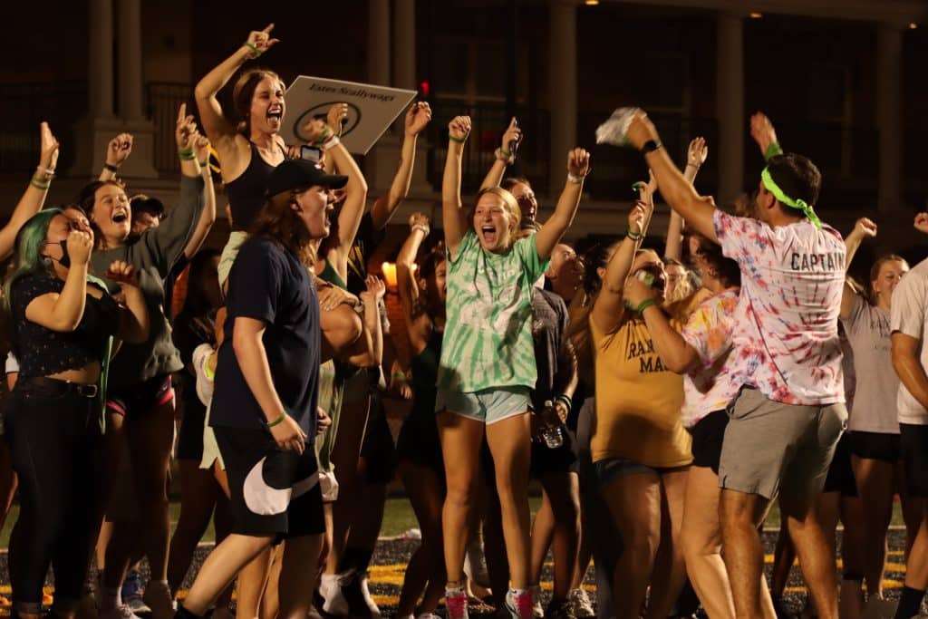 A group of transitioning college students cheering on a football field.