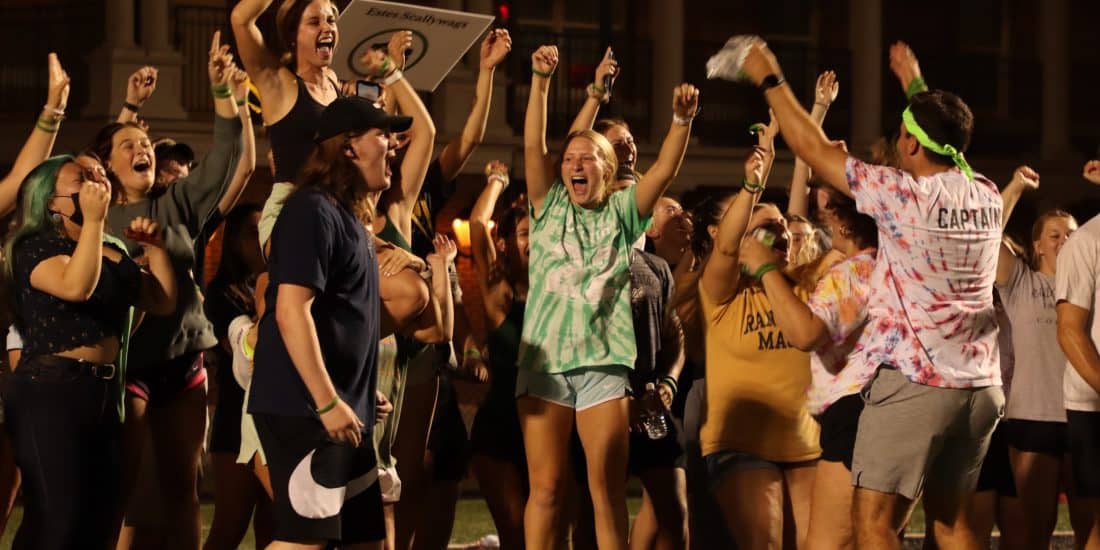 A group of college students cheering on a football field.