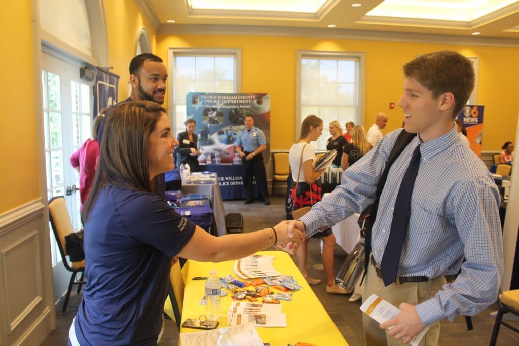 A man networking with a woman at a job fair for employers.