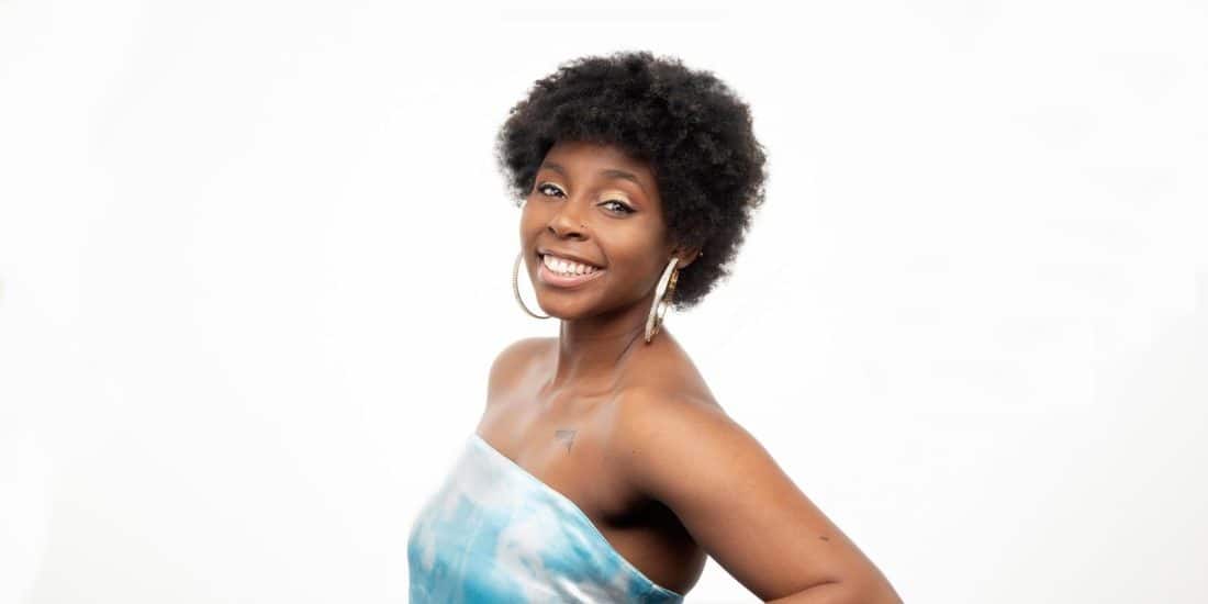 Nikia Lee '22 in a blue dress posing for a photo.