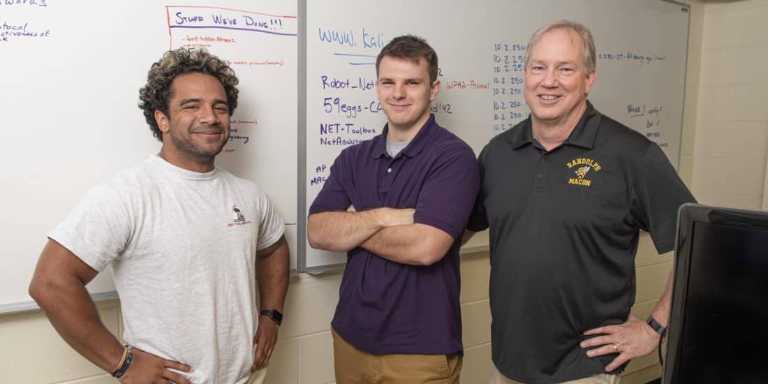 Seth Ravenstahl, Jordan Foster, and Professor John McManus stading in front of a white board