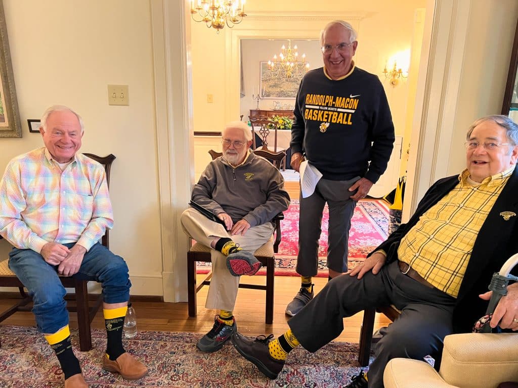 Four members of the Boydton Society pose for a photo showing off their RMC socks. 
