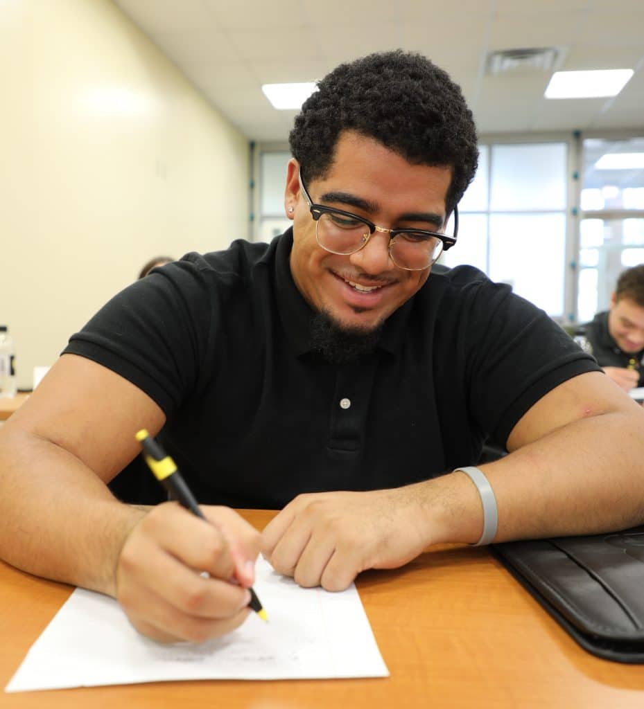 A man wearing a black shirt, during job interviews, compares resumes and CVs.