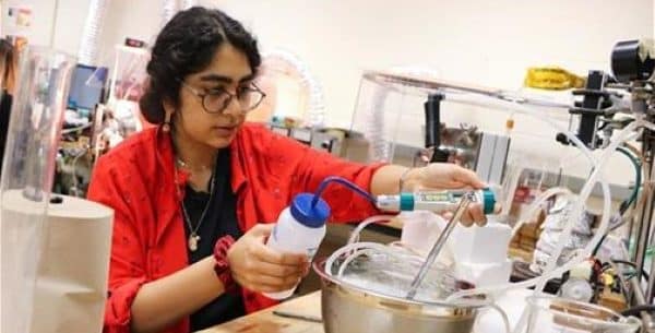 A close-up of Huma Jafree as she measures water quality in her air gap membrane distillation system