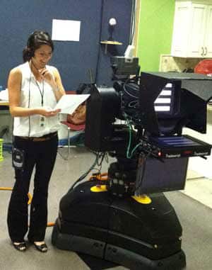 Lena Wallace standing in front of a television camera.