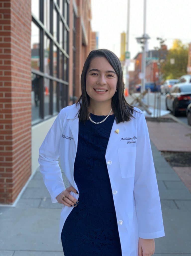 RMC alumna Madeleine Purcell poses for a headshot in a lab coat.