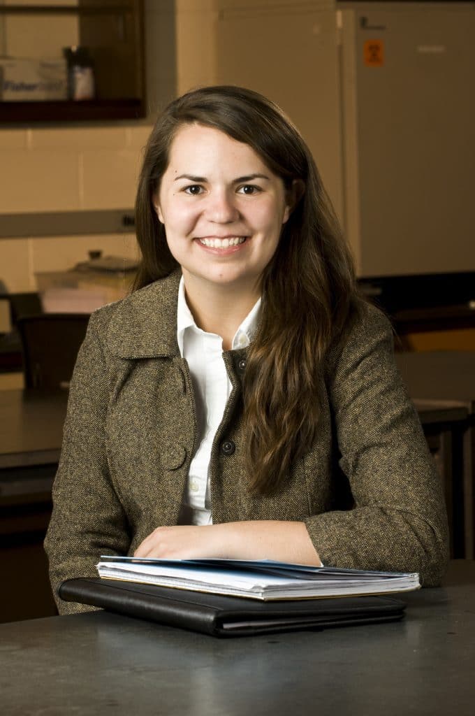Lauren Cox Sweeney '10 sitting at a table in a lab.