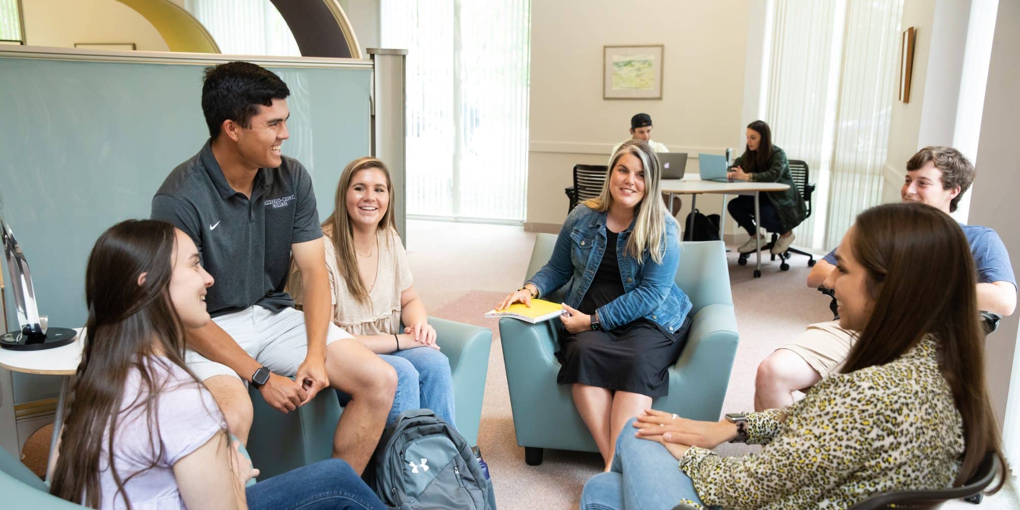 A group of students discussing with an RMC staff member in the library.