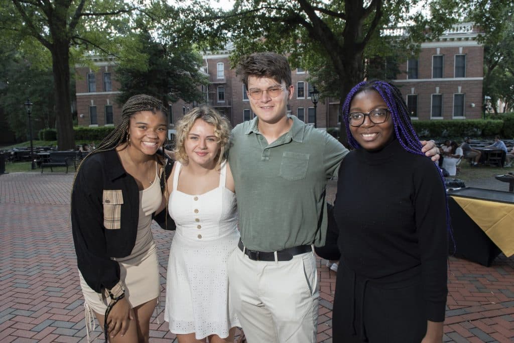 Four RMC students pose for a picture in fountain plaza