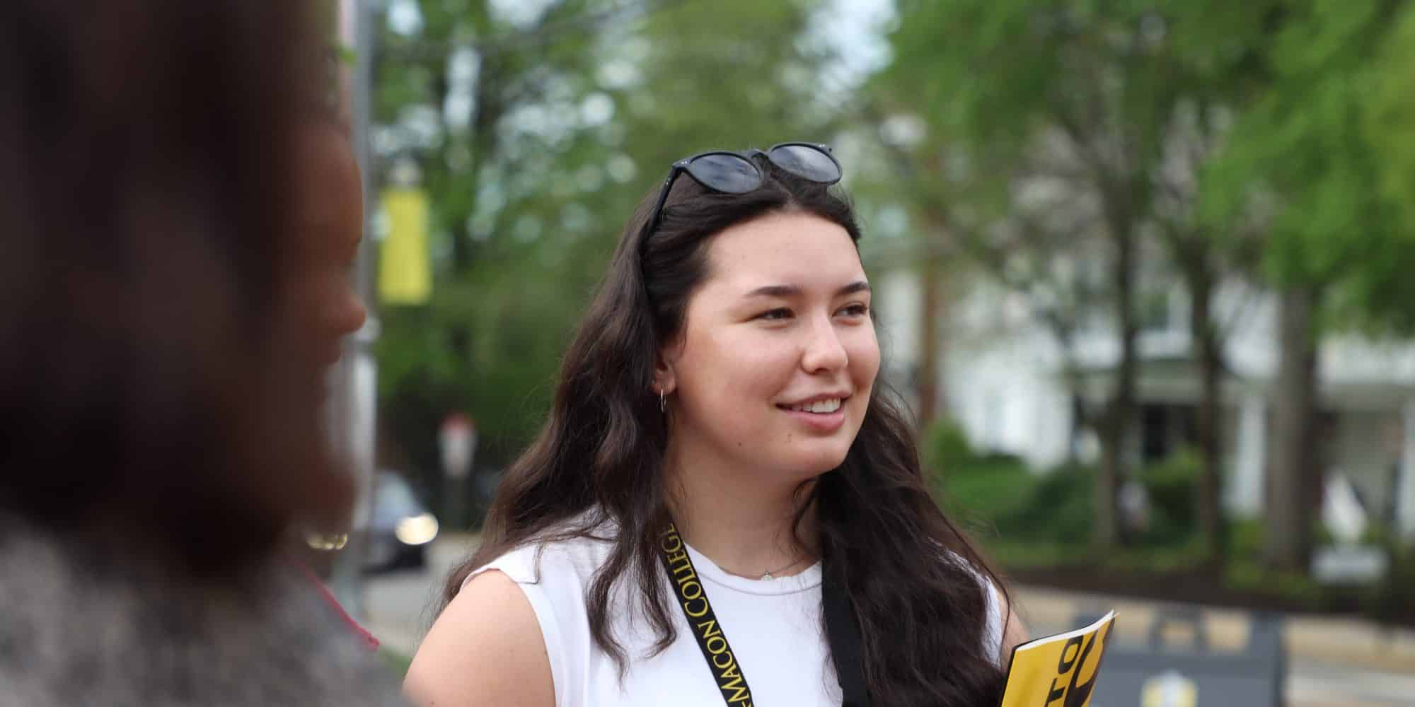 A student listens during an Admitted Students information session outside.