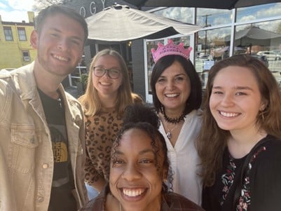 A group of German tourists posing for a photo in front of a restaurant.