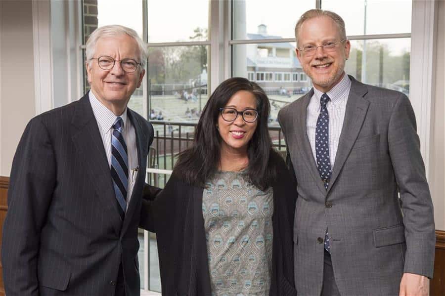 Three people in business attire posing for a photo at the J. Earl Moreland Lecture Series.