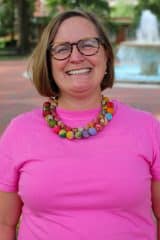 Megan Mudd smiles in front of a fountain.