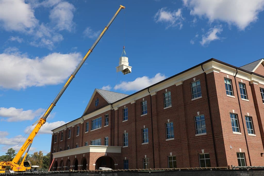 Duke Hall with a crane in front. place the cupola on top of the building 